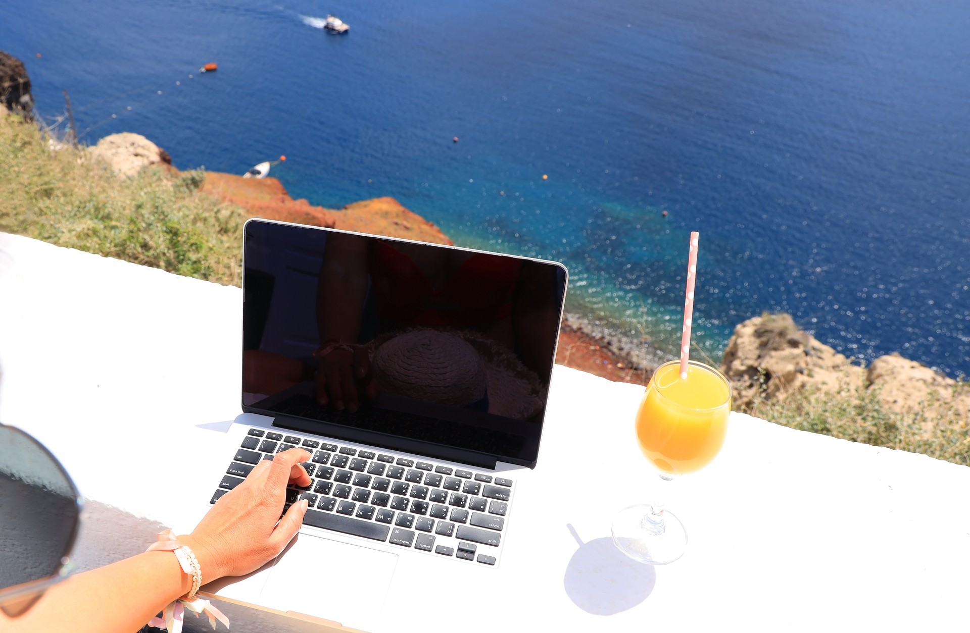 Nomad digital with laptop and running remotely with bright scenic view of the Mediterranean Sea